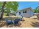 Backyard with a small patio area and three blue chairs, ideal for outdoor relaxation and entertaining at 8608 N Arden Ave, Tampa, FL 33604