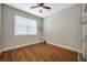 Bedroom featuring wood-look flooring, a ceiling fan and a large window overlooking the front yard at 8608 N Arden Ave, Tampa, FL 33604