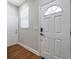 Bright entryway with wood-look flooring, white trim, and a door with decorative window at 8608 N Arden Ave, Tampa, FL 33604