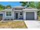 Charming single-story home featuring a gray exterior, a one-car garage, and manicured landscaping at 8608 N Arden Ave, Tampa, FL 33604