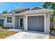 Charming single-story home with gray paint, gray trim, and a gray garage door at 8608 N Arden Ave, Tampa, FL 33604