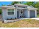 Beautifully landscaped single-story home featuring a gray exterior with a one-car garage at 8608 N Arden Ave, Tampa, FL 33604
