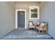 Inviting front porch with seating area, decorative pillows and a colorful welcome mat at 8608 N Arden Ave, Tampa, FL 33604