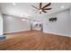 Open concept living room with kitchen view, hardwood floors, and modern ceiling fan at 8608 N Arden Ave, Tampa, FL 33604