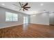 Open-concept living room with wood-look tile flooring, sliding doors to lanai, and modern ceiling fan at 8608 N Arden Ave, Tampa, FL 33604