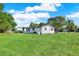 Spacious green backyard featuring mature trees and bright home exterior at 9266 Century Dr, Spring Hill, FL 34606
