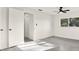 Bright bedroom features a ceiling fan, gray floors, neutral walls and a large window overlooking the yard at 9266 Century Dr, Spring Hill, FL 34606
