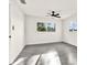 Bright bedroom features a ceiling fan, gray floors, neutral walls and two large windows overlooking the yard at 9266 Century Dr, Spring Hill, FL 34606