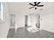 Bright bedroom features ceiling fan, gray floors, neutral walls, and view to en-suite bathroom with tiled shower at 9266 Century Dr, Spring Hill, FL 34606