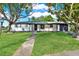 Charming single story home featuring a lush green lawn, mature trees, and neutral paint scheme at 9266 Century Dr, Spring Hill, FL 34606