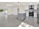 Kitchen featuring stainless appliances, a gray kitchen island, and modern backsplash at 9266 Century Dr, Spring Hill, FL 34606