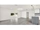 Open-concept living space with modern lighting, gray flooring, and slider access to outdoor living at 9266 Century Dr, Spring Hill, FL 34606