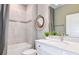 Bathroom with a tiled shower-tub combo, white vanity, and decorative mirror at 9542 Coastline Way, Parrish, FL 34219