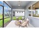Enclosed lanai with cushioned seating, a coffee table, and a view of the backyard at 9542 Coastline Way, Parrish, FL 34219