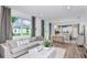 Inviting living room with a comfortable sofa, wood flooring, and plenty of natural light at 9542 Coastline Way, Parrish, FL 34219