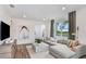 Modern living room with a comfortable sectional sofa, wood flooring, and natural light at 9542 Coastline Way, Parrish, FL 34219