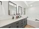 Stylish bathroom with double vanity, gray cabinets, and a luxurious soaking tub at 970 Ridgewood Ter, Tarpon Springs, FL 34689