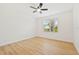 Bright bedroom with light wood floors, a ceiling fan, and a window view at 970 Ridgewood Ter, Tarpon Springs, FL 34689