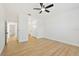 Spacious bedroom with light wood flooring, ceiling fan, and access to ensuite bathroom at 970 Ridgewood Ter, Tarpon Springs, FL 34689