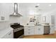 Kitchen with white cabinets, stainless steel appliances, and hardwood floors at 970 Ridgewood Ter, Tarpon Springs, FL 34689