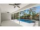 Relaxing pool area with a screened enclosure, ceiling fans, and lush landscaping at 970 Ridgewood Ter, Tarpon Springs, FL 34689