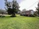 Expansive backyard with mature trees, lush lawn, a white fence, and a charming shed at 1002 W Pinedale Dr, Plant City, FL 33563