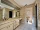 A spacious bathroom featuring a large mirror and vanity, with floral wallpaper at 1002 W Pinedale Dr, Plant City, FL 33563