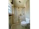 Bathroom featuring a shower with gold trim, next to a toilet and window at 1002 W Pinedale Dr, Plant City, FL 33563