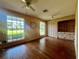 Bright bedroom with hardwood floors, two ceiling fans, and large windows at 1002 W Pinedale Dr, Plant City, FL 33563
