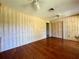 Bedroom with wood paneling, hardwood flooring, and a ceiling fan at 1002 W Pinedale Dr, Plant City, FL 33563
