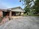 Covered carport with brick columns, adjacent to the brick home and lush backyard at 1002 W Pinedale Dr, Plant City, FL 33563