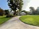 Charming one story brick home with manicured lawn, mature trees and a circular driveway at 1002 W Pinedale Dr, Plant City, FL 33563
