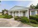 Classic brick home with white columns, covered porch, meticulous landscaping, and security system at 1002 W Pinedale Dr, Plant City, FL 33563