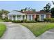 Charming brick home with a welcoming front porch, mature trees, and a well-maintained lawn at 1002 W Pinedale Dr, Plant City, FL 33563