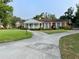 Inviting brick home featuring a long driveway and ample parking, set against a backdrop of mature trees at 1002 W Pinedale Dr, Plant City, FL 33563