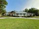 Charming brick home with a manicured lawn, covered porch with columns, and a circular driveway at 1002 W Pinedale Dr, Plant City, FL 33563