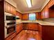 Well-equipped kitchen with stainless steel appliances, wooden cabinets, granite countertops and hardwood flooring at 1002 W Pinedale Dr, Plant City, FL 33563