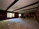 An expansive living room featuring wood paneling, exposed ceiling beams, and large windows at 1002 W Pinedale Dr, Plant City, FL 33563
