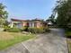Brick home with manicured landscaping, a paved driveway, and an attached covered carport at 1002 W Pinedale Dr, Plant City, FL 33563