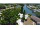 Aerial view of single-story home situated on waterfront property with private dock surrounded by mature trees at 10744 Drummond Rd, Tampa, FL 33615