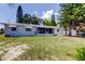Backyard of a single-story waterfront house with a screened-in porch and a well-maintained lawn at 10744 Drummond Rd, Tampa, FL 33615