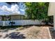 Backyard with white fence and tropical foliage to create privacy and add a touch of nature at 10744 Drummond Rd, Tampa, FL 33615