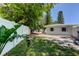 View of the backyard with white fencing, lush tropical plants, and glimpses of the home's exterior at 10744 Drummond Rd, Tampa, FL 33615