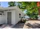 Home exterior featuring a side yard with neutral paint and access door, offering functionality at 10744 Drummond Rd, Tampa, FL 33615