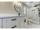 Elegant bathroom featuring modern vanity, sleek fixtures, framed mirror, and tiled walk-in shower at 10744 Drummond Rd, Tampa, FL 33615