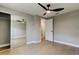 Bright bedroom features wood-look flooring, modern ceiling fan, and closet with mirrored doors at 10744 Drummond Rd, Tampa, FL 33615