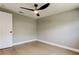 Bedroom with gray walls, wood-look flooring, and a modern ceiling fan at 10744 Drummond Rd, Tampa, FL 33615