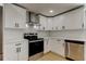 Modern kitchen featuring white cabinets, stainless steel appliances, and a stainless steel range hood at 10744 Drummond Rd, Tampa, FL 33615