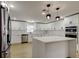 Modern kitchen with white cabinets, stainless steel appliances, quartz countertops, and a center island at 10744 Drummond Rd, Tampa, FL 33615