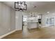 Open-concept living space showcasing wood-look floors, modern lighting, and a seamless transition to the kitchen at 10744 Drummond Rd, Tampa, FL 33615